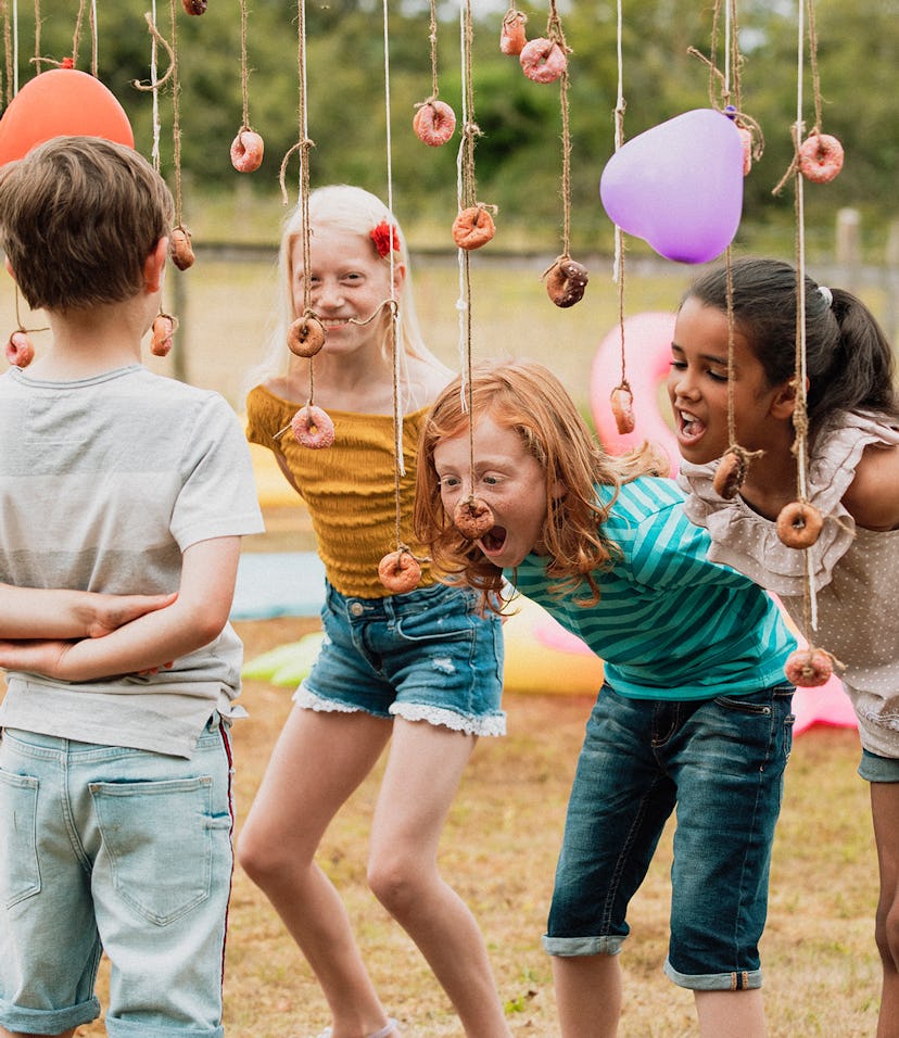Kids play a bobbing for donuts party game in a story about kids birthday party games, crafts, and ac...