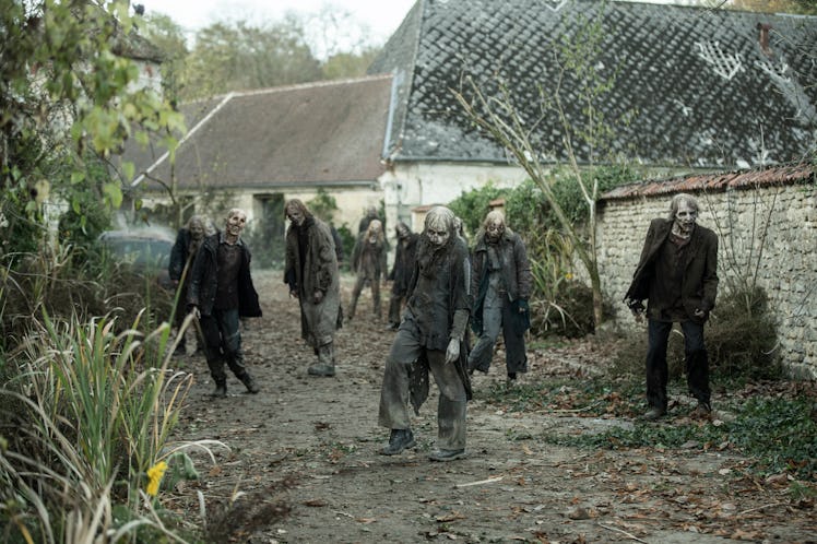 A horde of zombies walks through a post-apocalyptic street in 'The Walking Dead: Daryl Dixon' Season...
