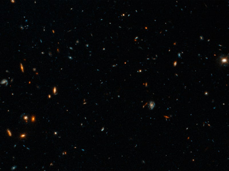 Hubble image showing numerous galaxies in various shapes and colors against the dark backdrop of spa...
