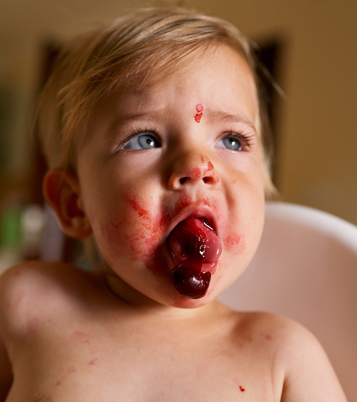 Toddler with messy face sits in a high chair and spits out a cherry, in a story explaining why your ...