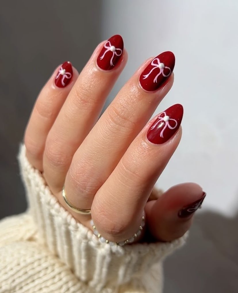 Coquette ribbon nail art on short almond nails are on-trend for 2024.