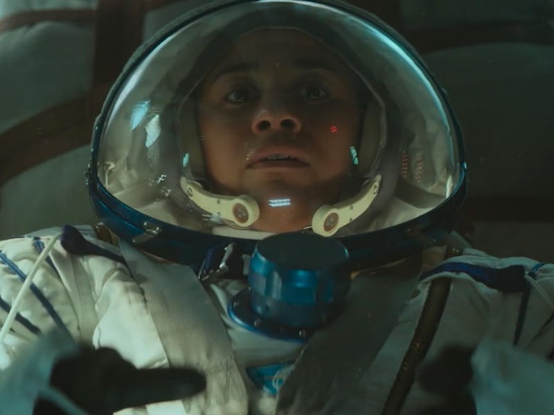 Astronaut with a look of concern wearing a helmet and spacesuit inside a spacecraft.