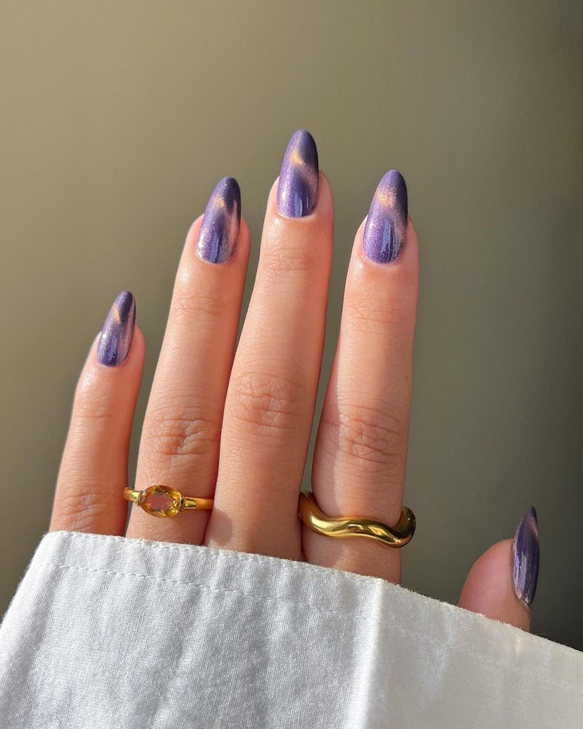 Purple cat eye details on short almond nails are on-trend for 2024.