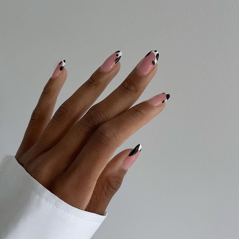 Cow print French tips on short almond nails are on-trend for 2024.