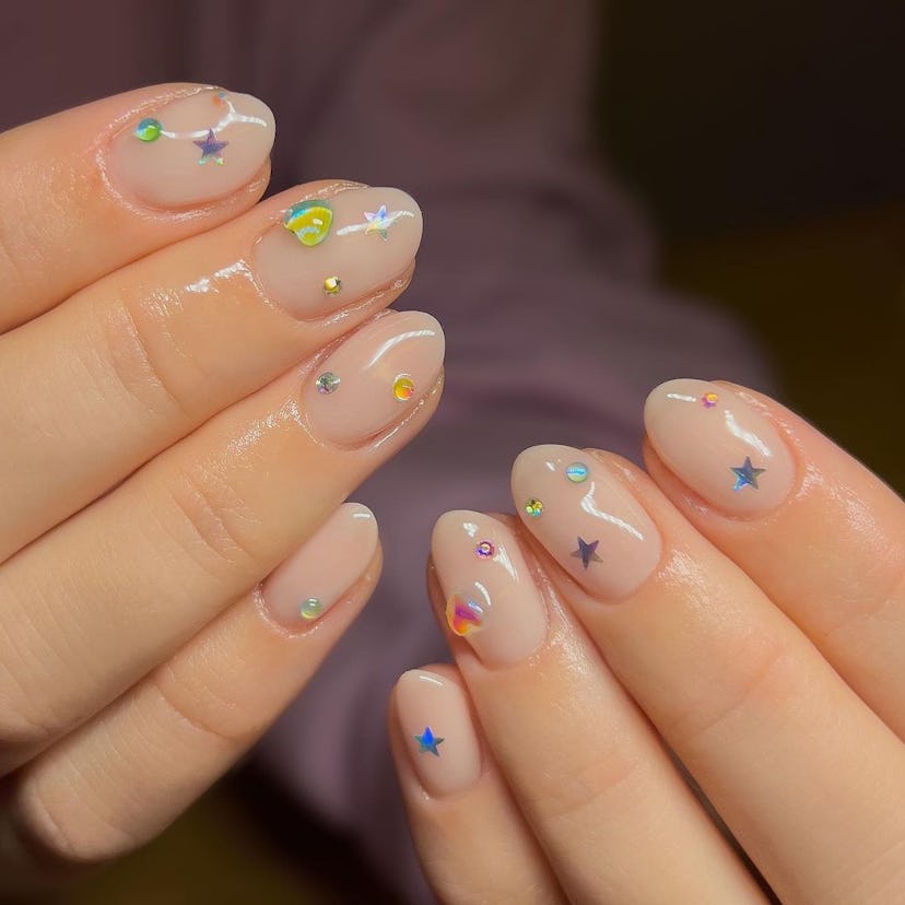 Holographic star stickers on short almond nails are on-trend for 2024.