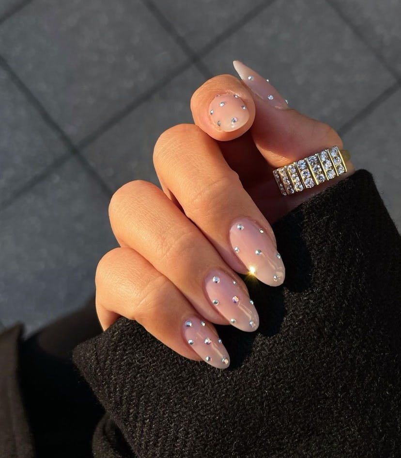 Simple rhinestone studs on short almond nails are on-trend for 2024.