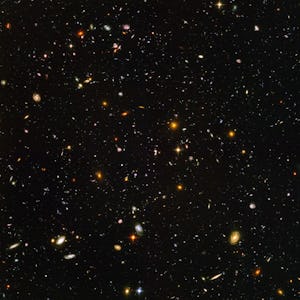 A vast expanse of space filled with countless stars and various colorful galaxies, showcasing the im...