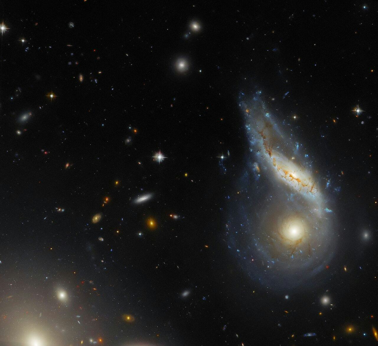 Two spiral galaxies are merging together at the right side of the image. One is seen face-on and is ...