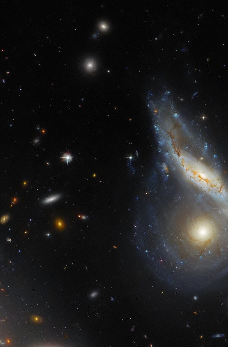 Two spiral galaxies are merging together at the right side of the image. One is seen face-on and is ...