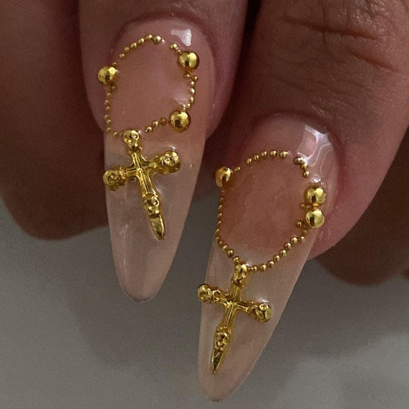 Neutral nails with 3D rosary nail art matches the mob wife aesthetic.