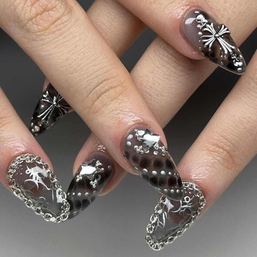 Edgy silver nail jewelry is on-trend for 2024’s Aquarius season.