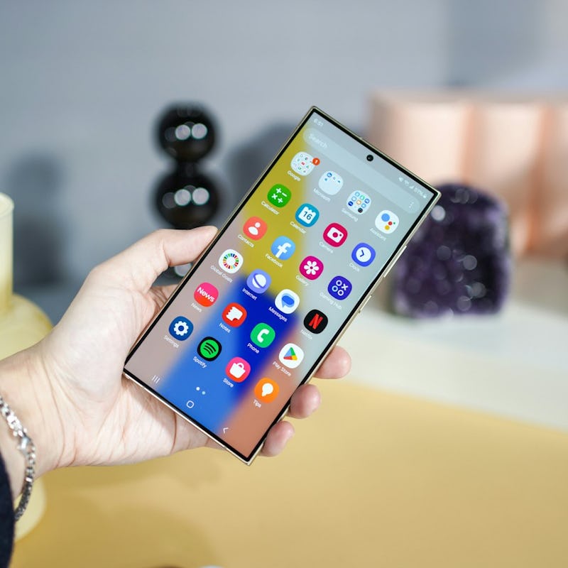 A hand holding a Samsung Galaxy S24 Ultra with a bunch of apps on the screen.
