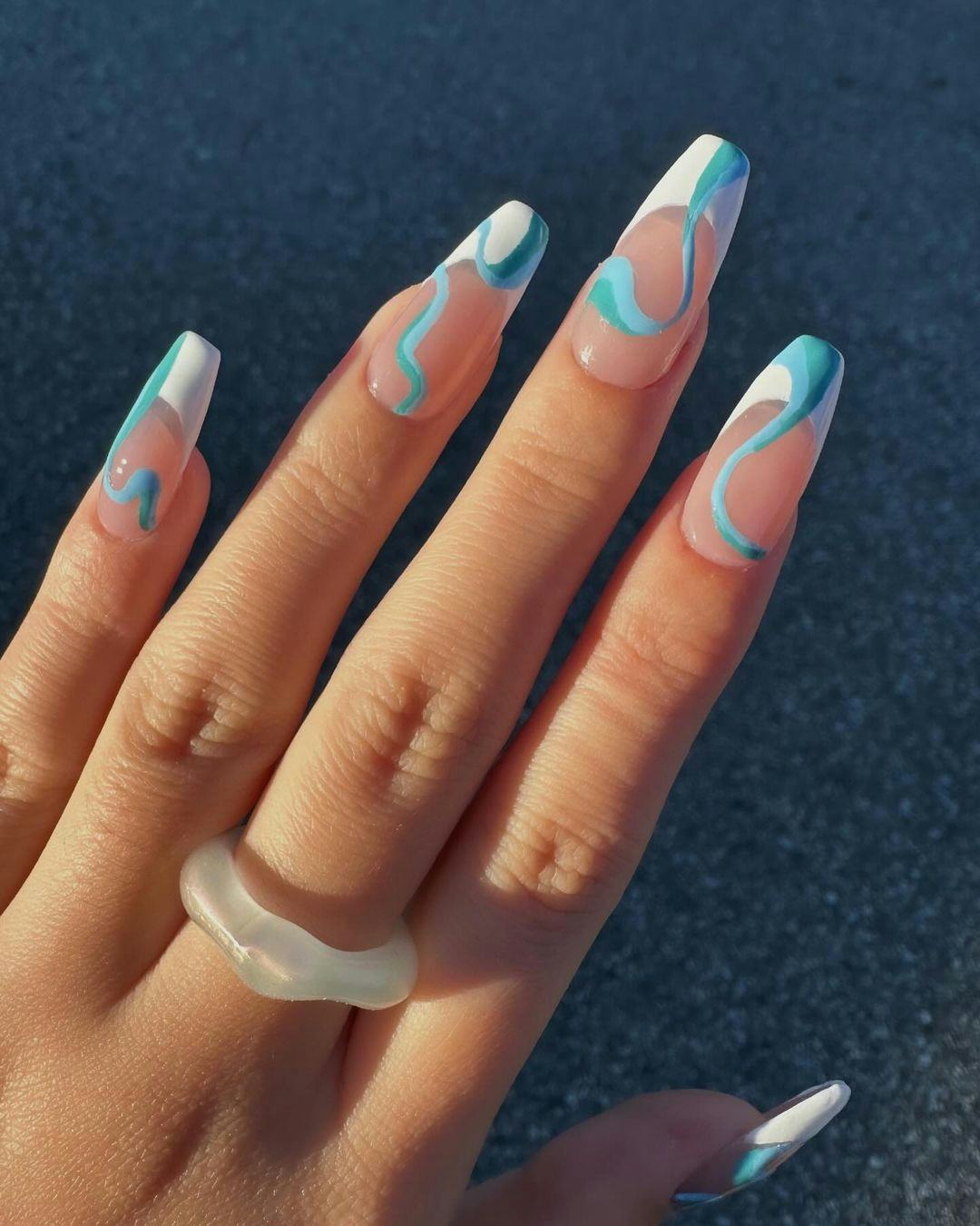 French tip nails with aqua blue swirls are on-trend for 2024&rsquo;s Aquarius season.
