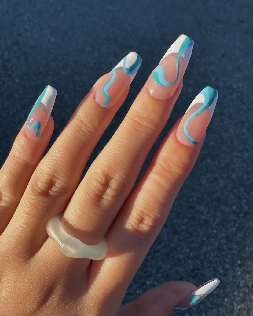 French tip nails with aqua blue swirls are on-trend for 2024’s Aquarius season.