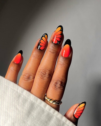 A arte das unhas com borboleta monarca laranja está na moda para a temporada de Aquário de 2024.