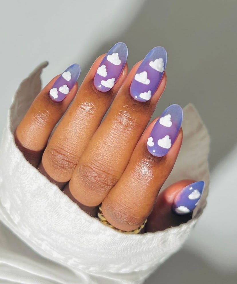 Cartoon cloud designs on lavender nails are on-trend for 2024’s Aquarius season.