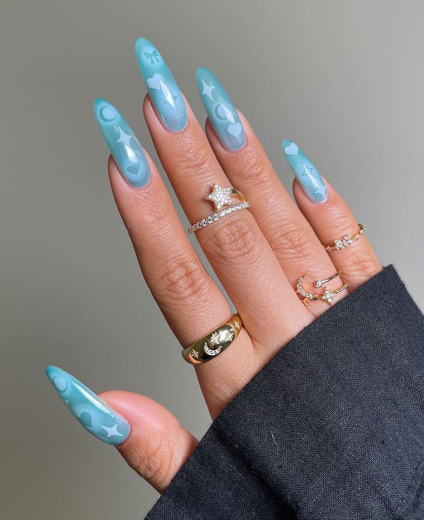 Aqua blue nails with airbrushed details are on-trend for 2024’s Aquarius season.