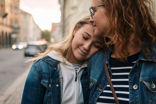 A teen snuggles up to her mom.