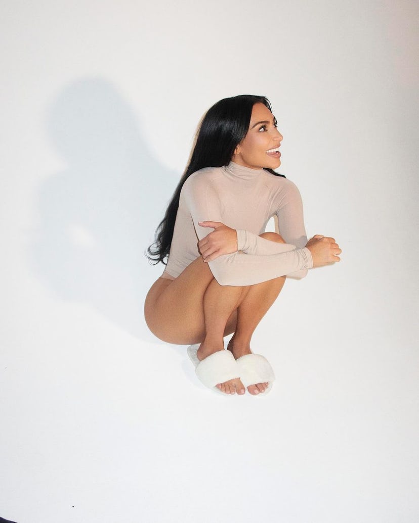 Kim Kardashian wears a beige long sleeve bodysuit. 
