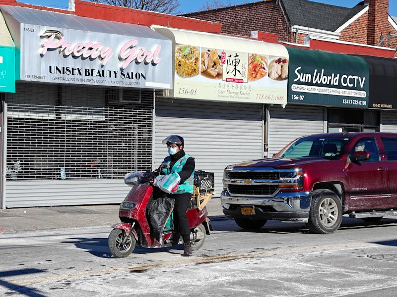 Photograph of a food delivery person riding a motorcycle taken with the OnePlus 12's 3x telephoto ca...