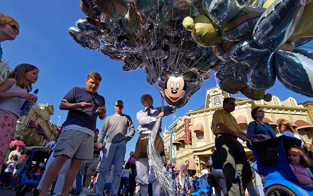 A dad pays for souvenir balloons at Walt Disney World.