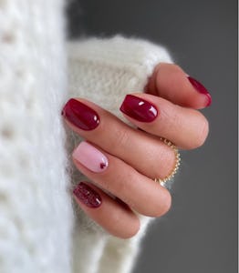 Red and pink Valentine's Day nails with glitter and tiny heart nail art.