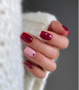 Red and pink Valentine's Day nails with glitter and tiny heart nail art.