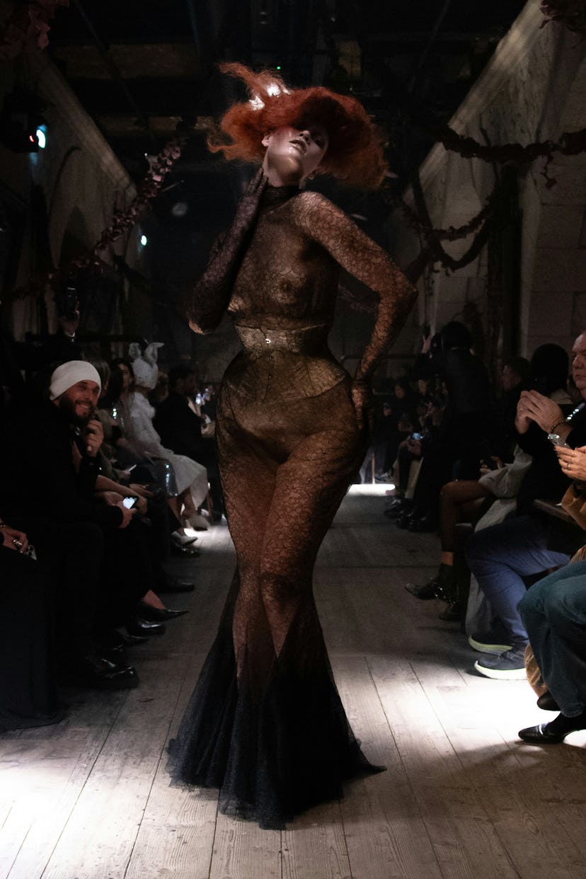 model walks the runway in a black lace dress at Courtesy of Maison Martin Margiela's 2024 paris cout...