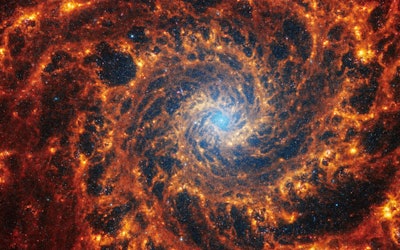 Webb’s image of NGC 628 shows a densely populated face-on spiral galaxy anchored by a central region...