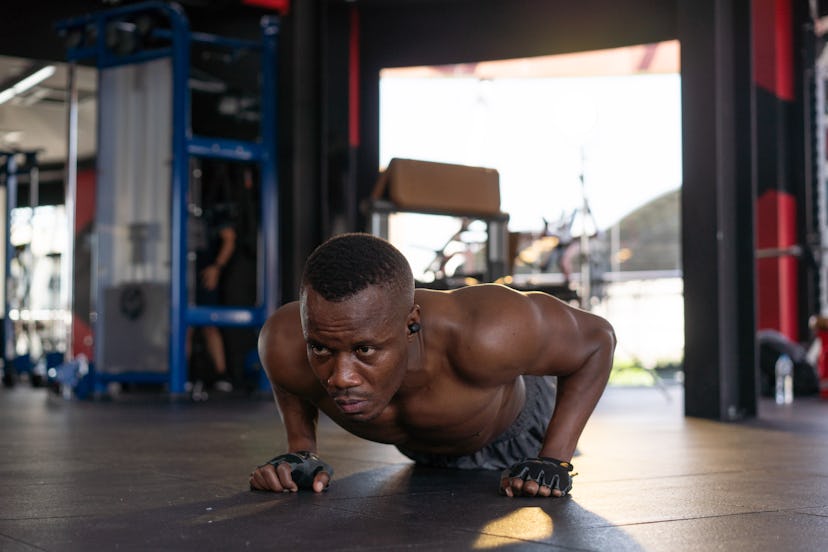 A man doing push-ups at a gym.
