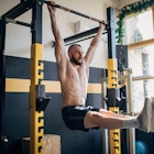 A man doing hanging leg raises in a home gym.