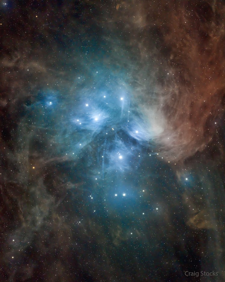 image of bright stars at the center of a cloud of dust in space, which glows blue at the center and ...
