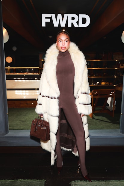 Lori Harvey wears a brown catsuit and a Khaite fur coat in Aspen, Colorado