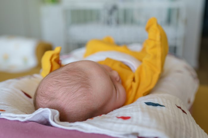 The top of a newborn's head while laying on. changing table in a story answering the question, when ...