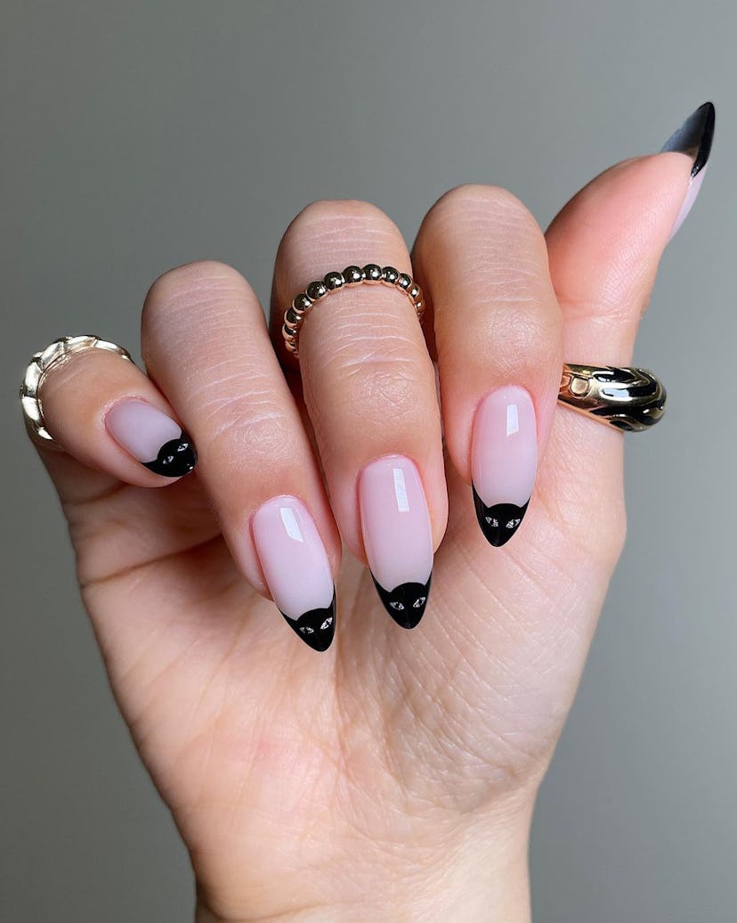 Black cat-inspired French tip nails are on-trend for 2024.