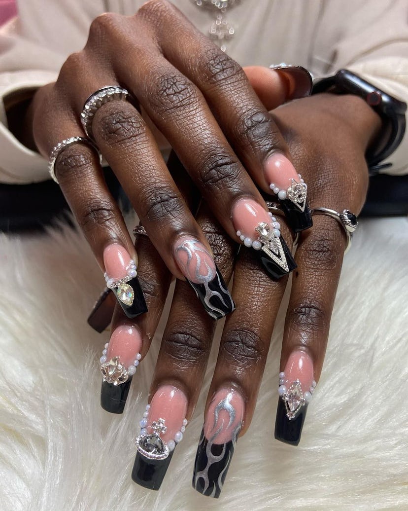 Black French tip nails with 3D adornments and silver chrome details are on-trend for 2024.
