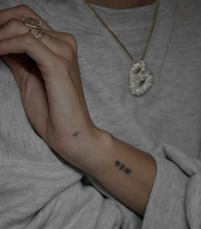 13 Adorable Coquette Tattoo Ideas Inspired by Hailey Bieber's Dainty Bow 27 Hailey Bieber's tiny bow tattoo.