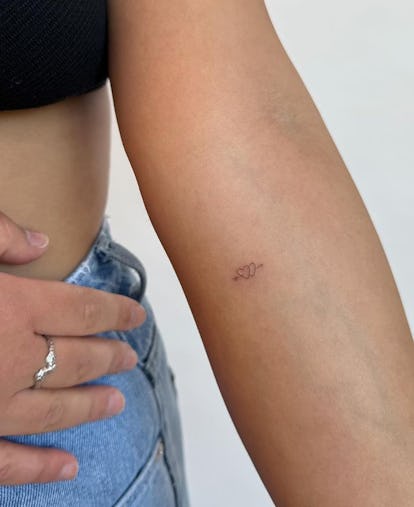 13 Adorable Coquette Tattoo Ideas Inspired by Hailey Bieber's Dainty Bow 31 Heart with arrow tattoo.