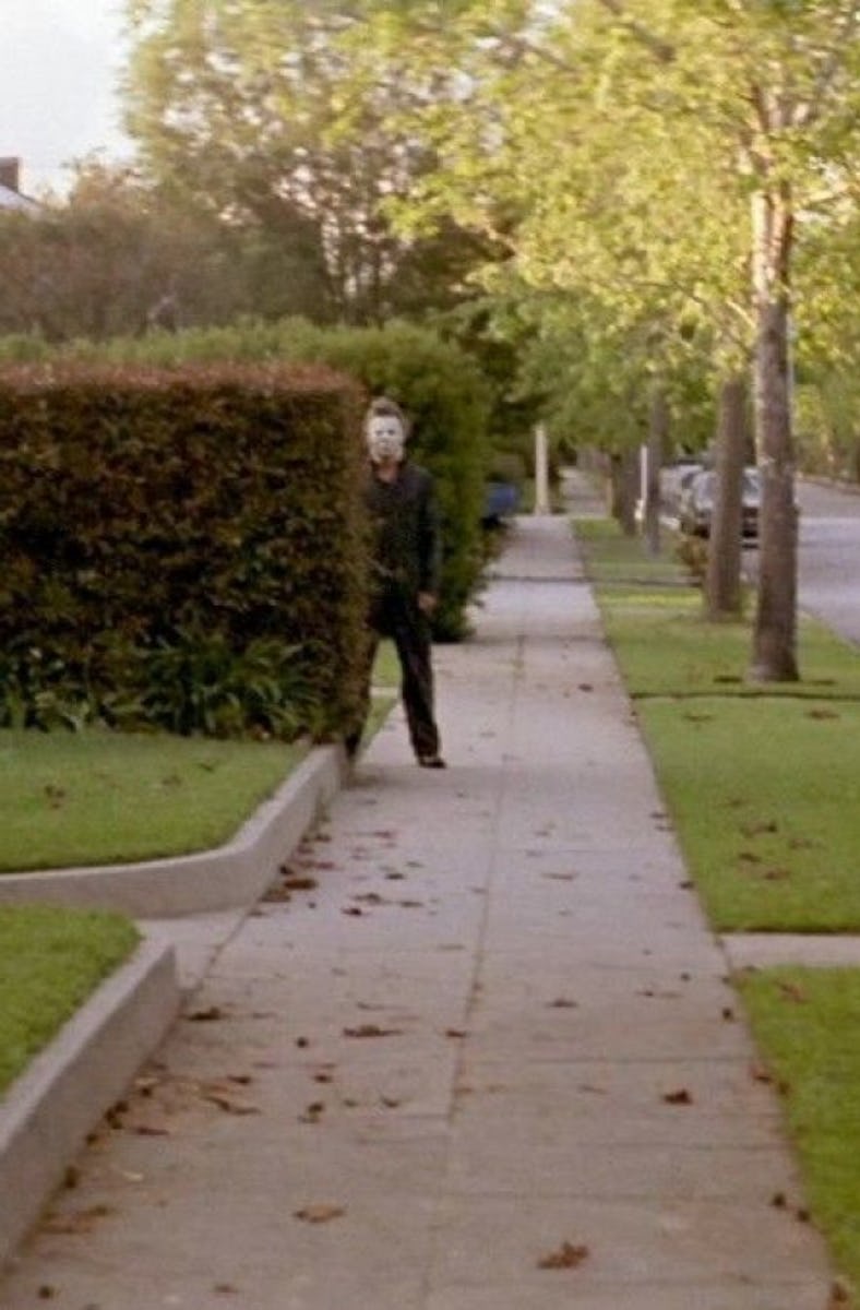 Michael Myers stands next to a hedge in 'Halloween'