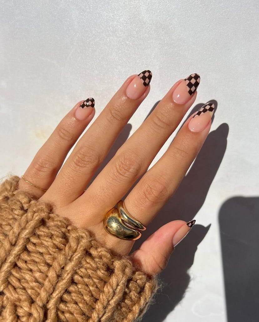 Checkerboard print French tips are a trendy French manicure idea for 2024.