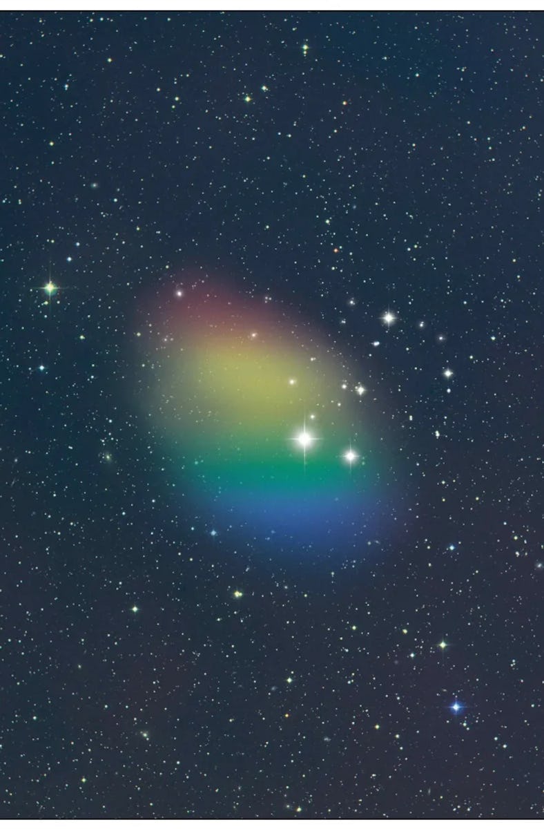 A hazy oval sits in the middle of a field of stars. The oval is split into about five rows of differ...
