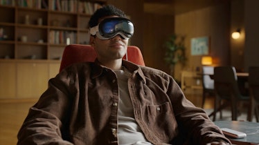 A man wearing Apple Vision Pro while sitting on a lounge chair.