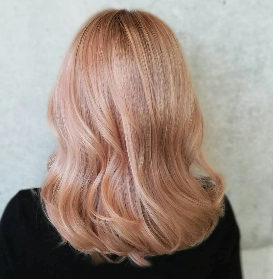 Peach-tinted blonde hair is on-trend for winter 2024.