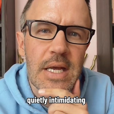 A man in a light blue hoodie, glasses, and a slight beard speaks thoughtfully into the camera, with the text "quietly intimidating" displayed.