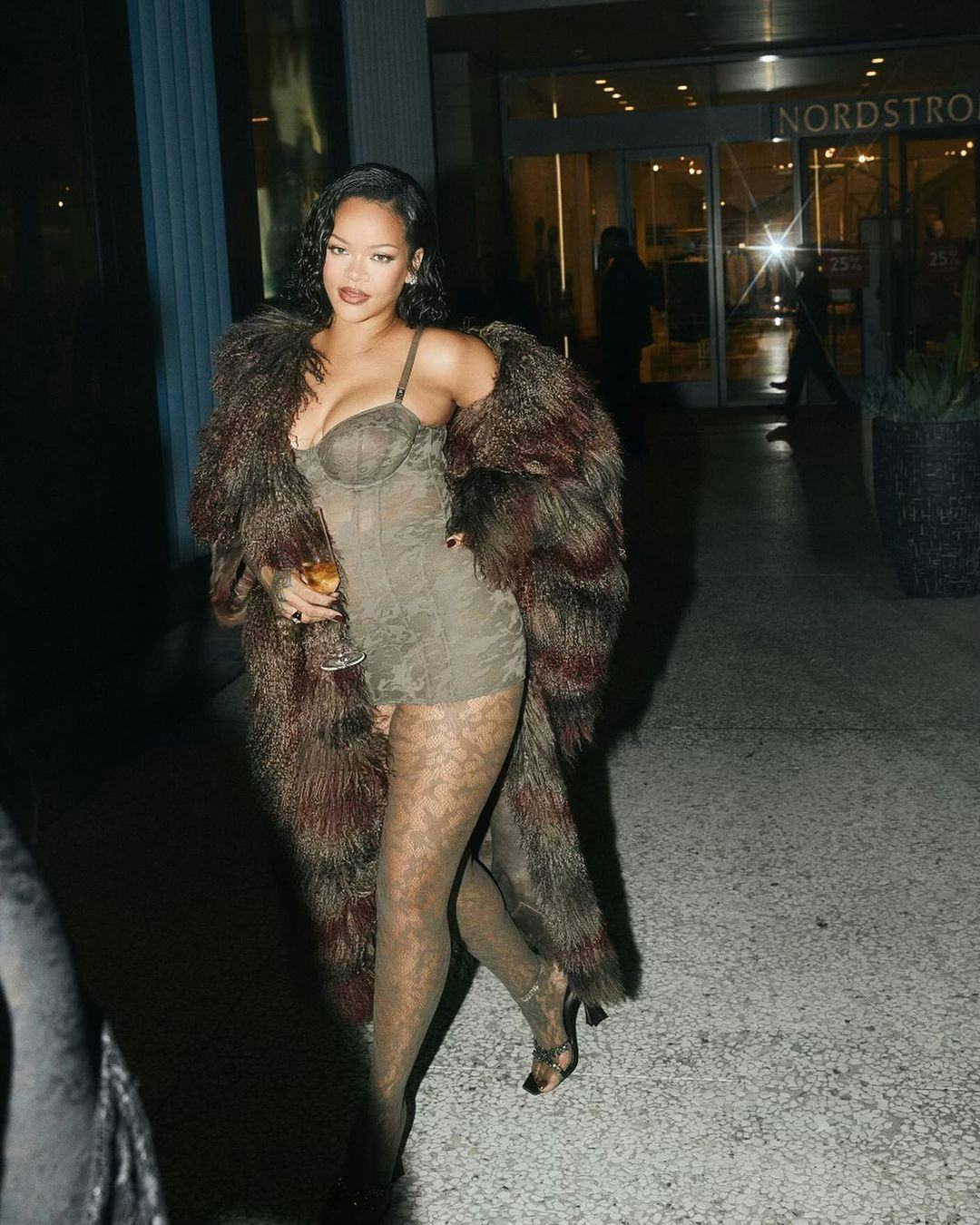 Rihanna wears a corset dress, tights, and a coat.