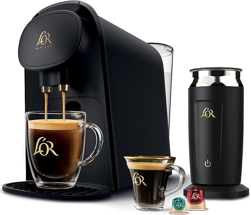 A sleek black coffee machine with two cups of coffee and colorful coffee pods beside a milk frother,...