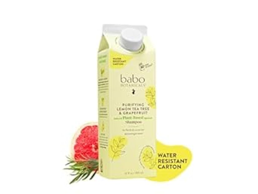 A carton of Babo Botanicals Purifying Lemon Tea Tree & Grapefruit Shampoo, featuring a yellow design...