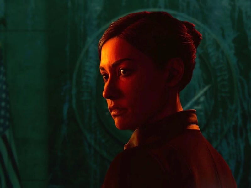 A woman with dark hair is portrayed in a profile against a dark background. Warm lighting highlights...