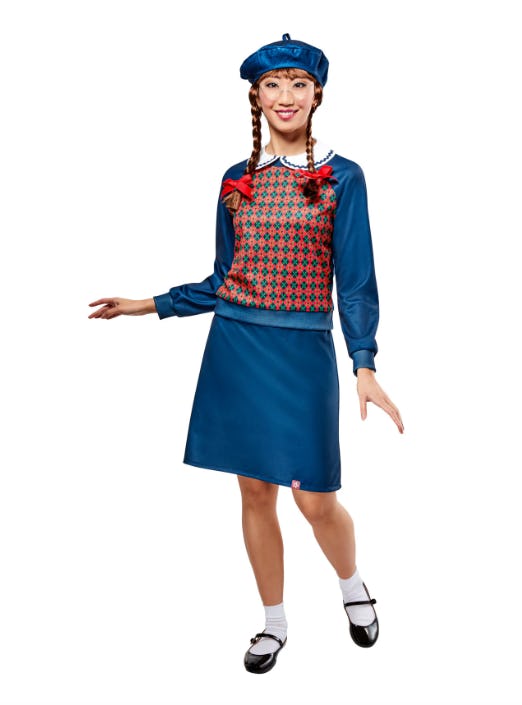 A model poses in a vibrant blue outfit featuring a patterned sweater, a matching skirt, and a blue beret, styled with braided hair and playful expressions.