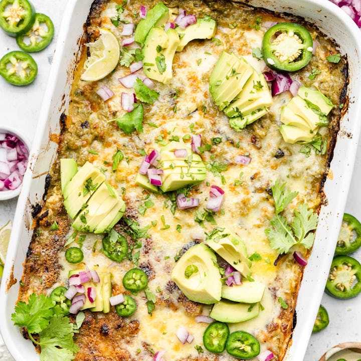 Chicken enchilada casserole in white dish topped with onion and avocado, in a list of easy casserole...